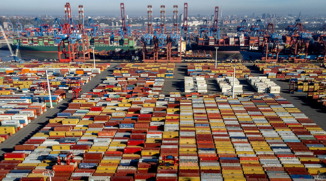 Shipping containers are stacked at a harbor in Hamburg, Germany